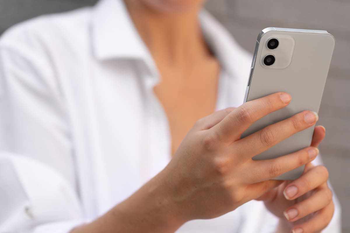 Usuário: Realme 9 Mulher com Realme 9 em mãos e usando blusa de botão branca