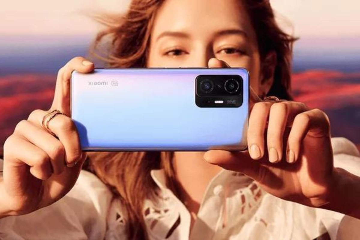 Vídeo: Xiaomi 11T Mulher segurando celular Xiaomi 11T azulado de lado como se gravasse vídeo com o mesmo com seus cabelos ao vento na foto