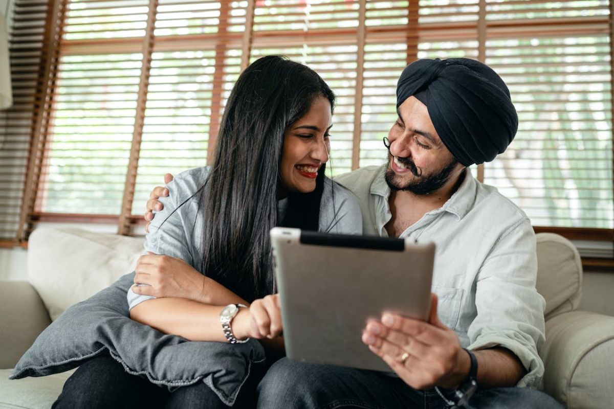 Tablet: Aplicativos de relacionamento Homem e mulher com tablet sorridentes se olhando enquanto usam Aplicativos de relacionamento