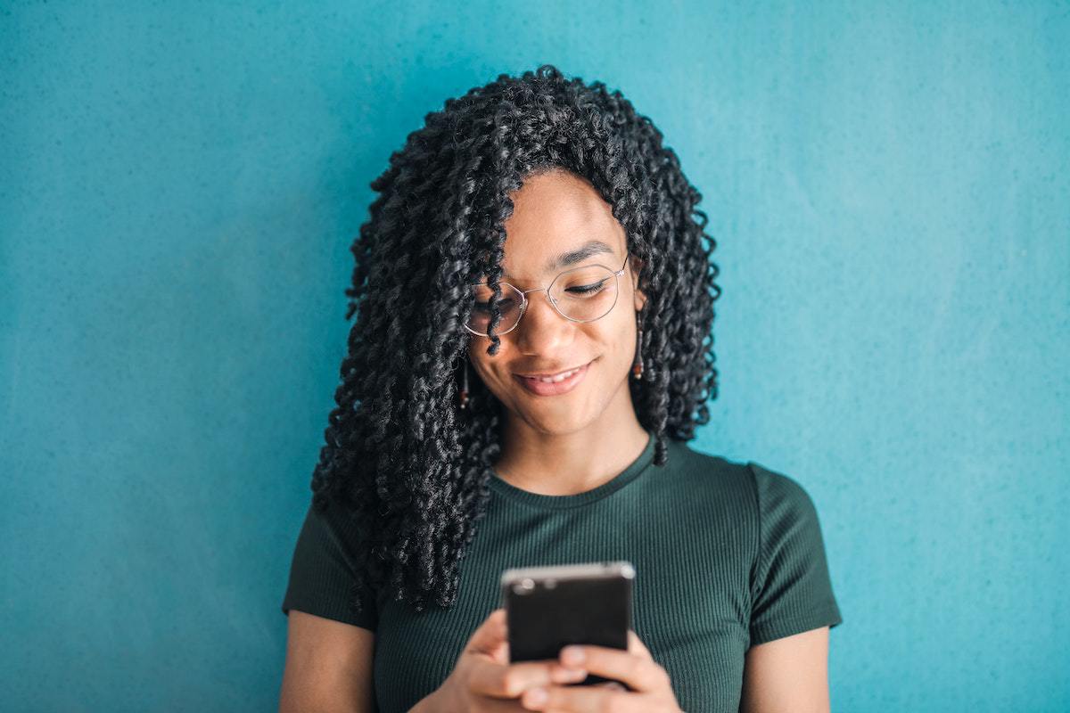 Alegria: Apps para aprender inglês Mulher mostrando alegria enquanto usa Apps para aprender inglês