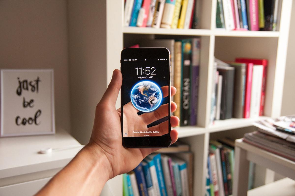 Usuário: Celular barato Celular barato na mão de usuário mostrando papel de parede
