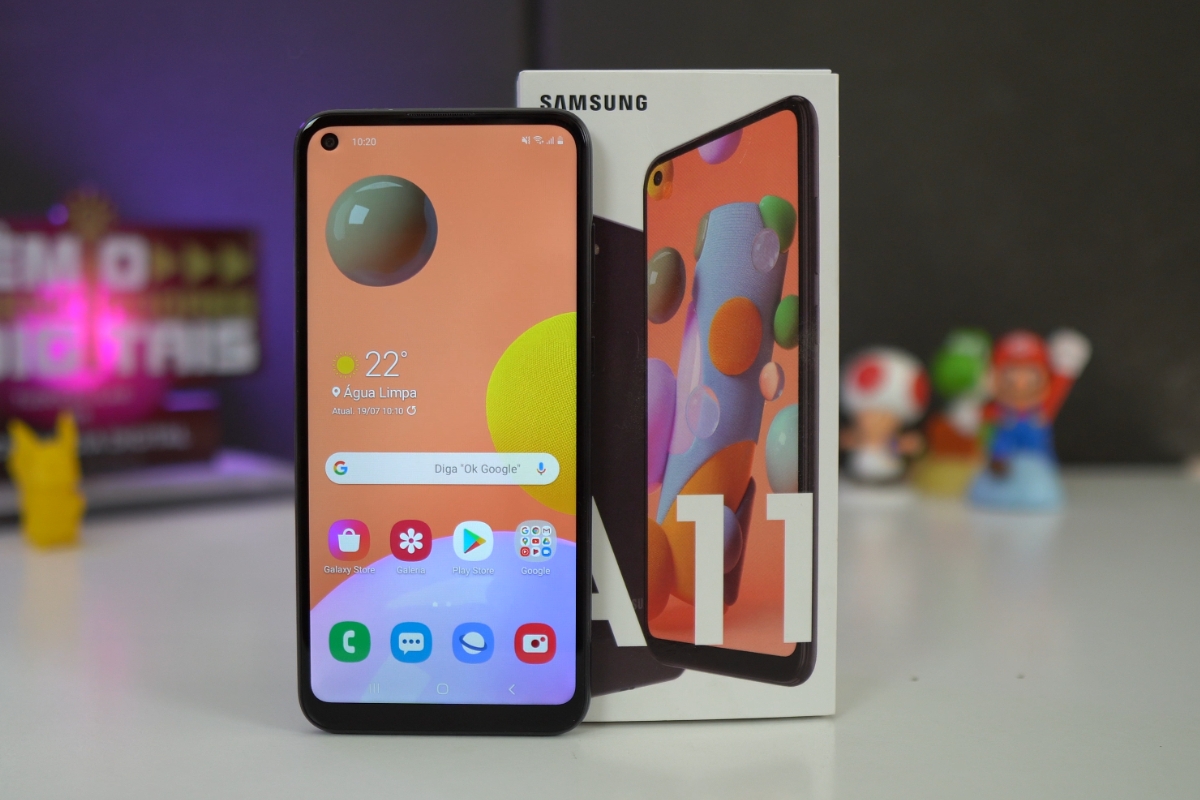 Galaxy A11 ao lado de sua caixa sobre mesa branca em, aparentemente, unboxing