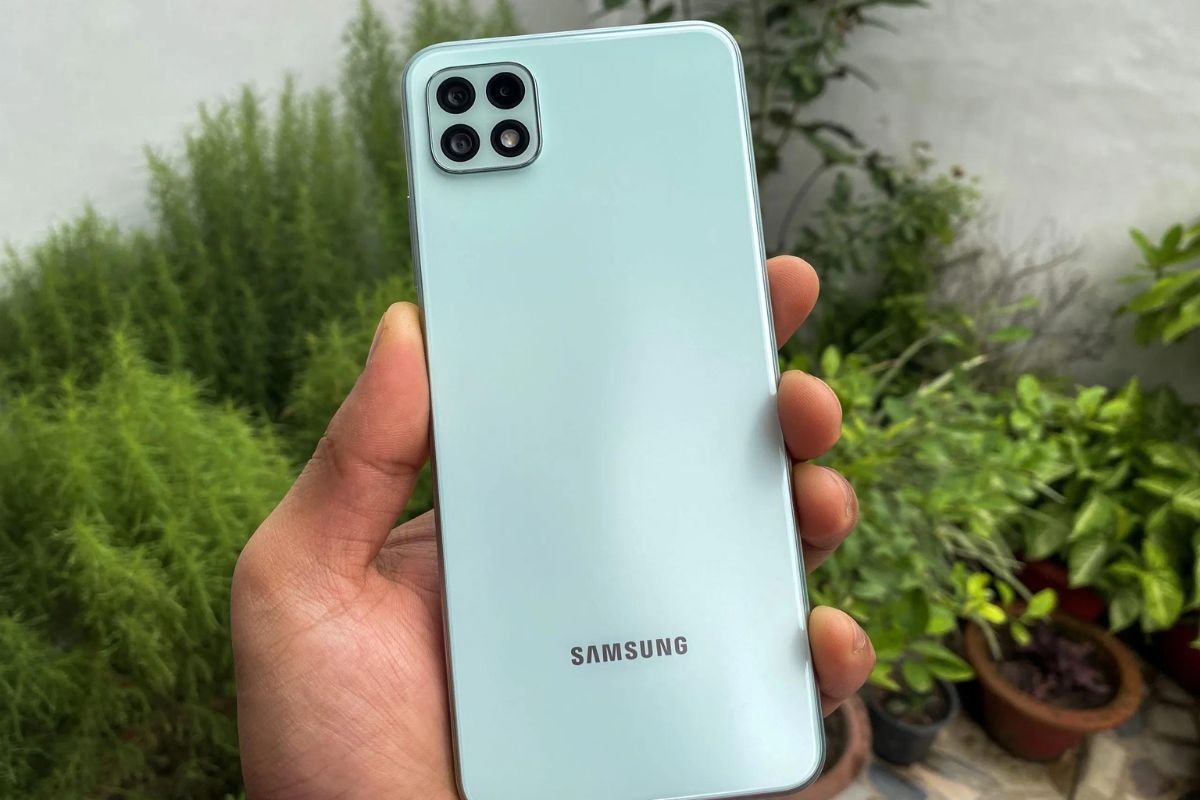 Galaxy A22 na mão de usuário diante de plantas