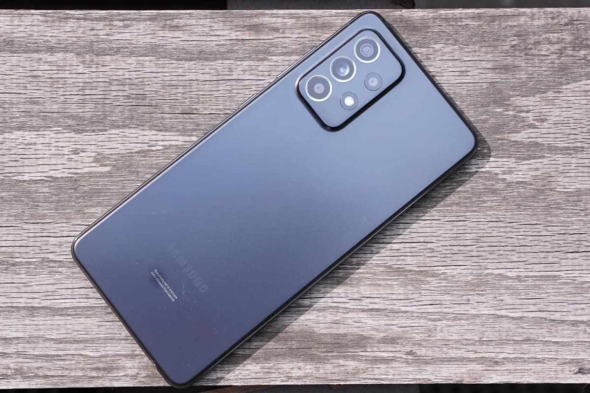 Câmeras: Galaxy A52 Galaxy A52 preto de costas para cima sobre superfície de madeira mostrando suas câmeras