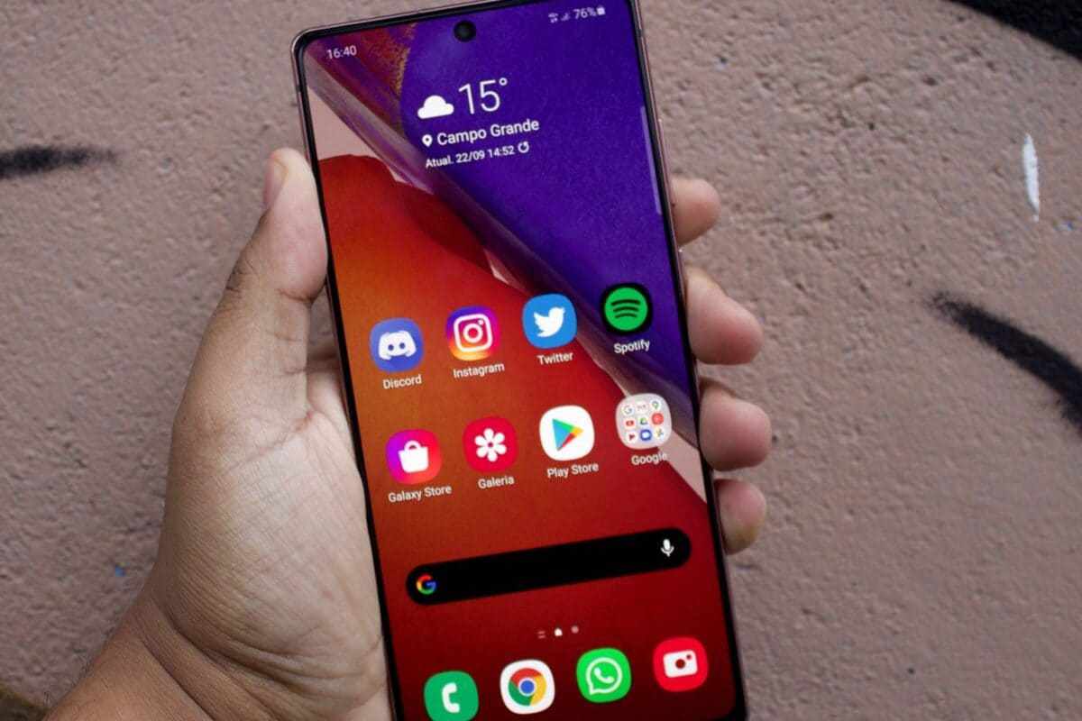 Galaxy Note 20 Ultra segurado por mão esquerda de usuário mostrando sua tela inicial