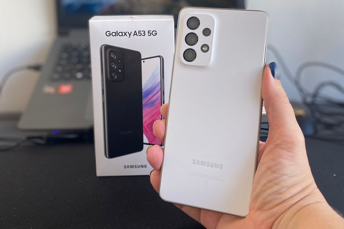 Usuário segurando Samsung Galaxy A53 ao lado de sua caixa