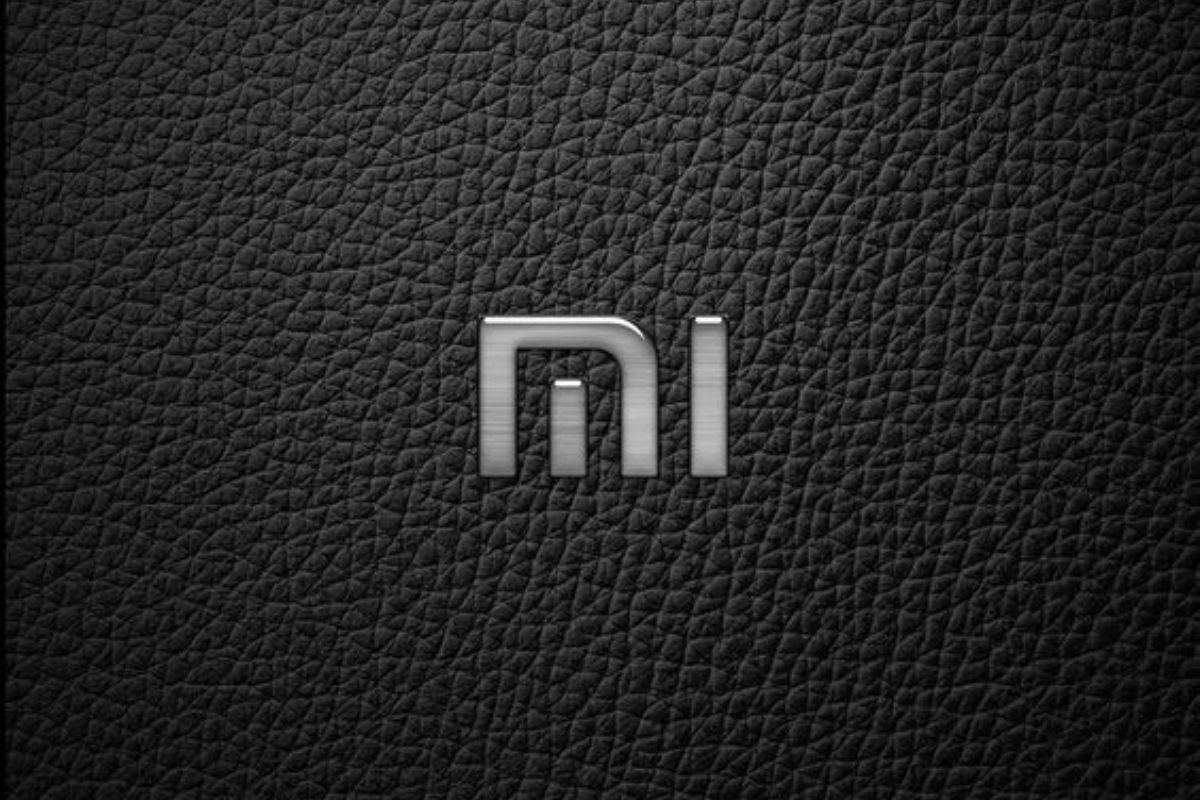 Símbolo ou logomarca da Xiaomi sobre superfície preta em tecido que lembra courino