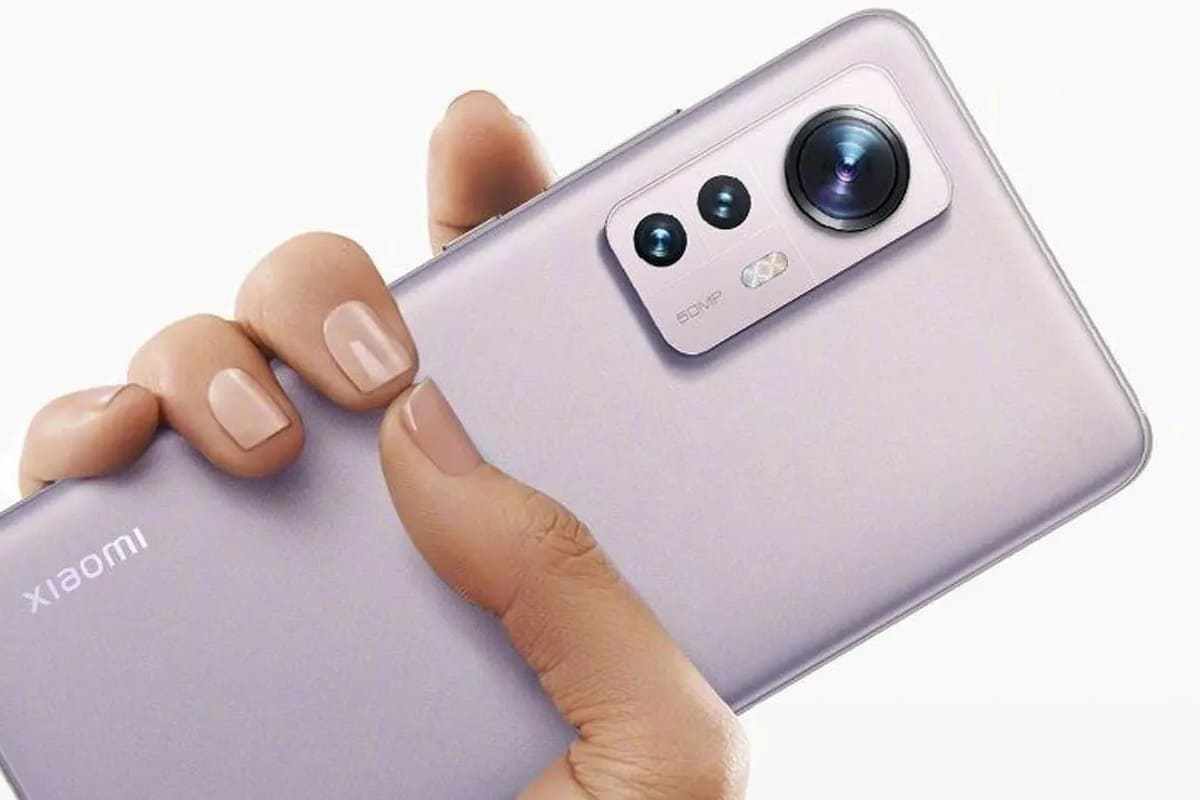 Câmeras: Xiaomi 12 Xiaomi 12 na mão de usuário na cor lilás, com unhas da mesma pintadas da mesma cor, com foco em suas câmeras