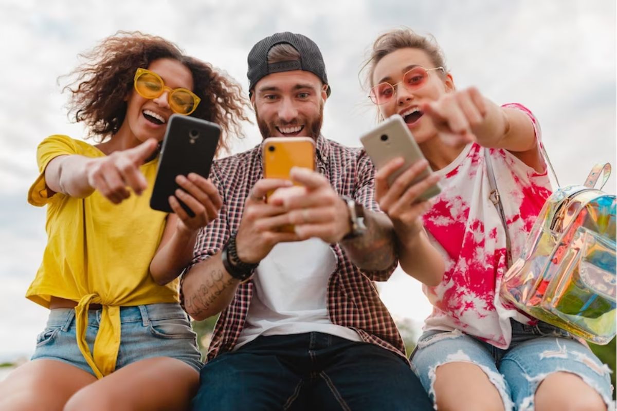 pessoas usando o celualr: aplicativos para baixar 3 pessoas usando seus respectivos celulares lado a lado
